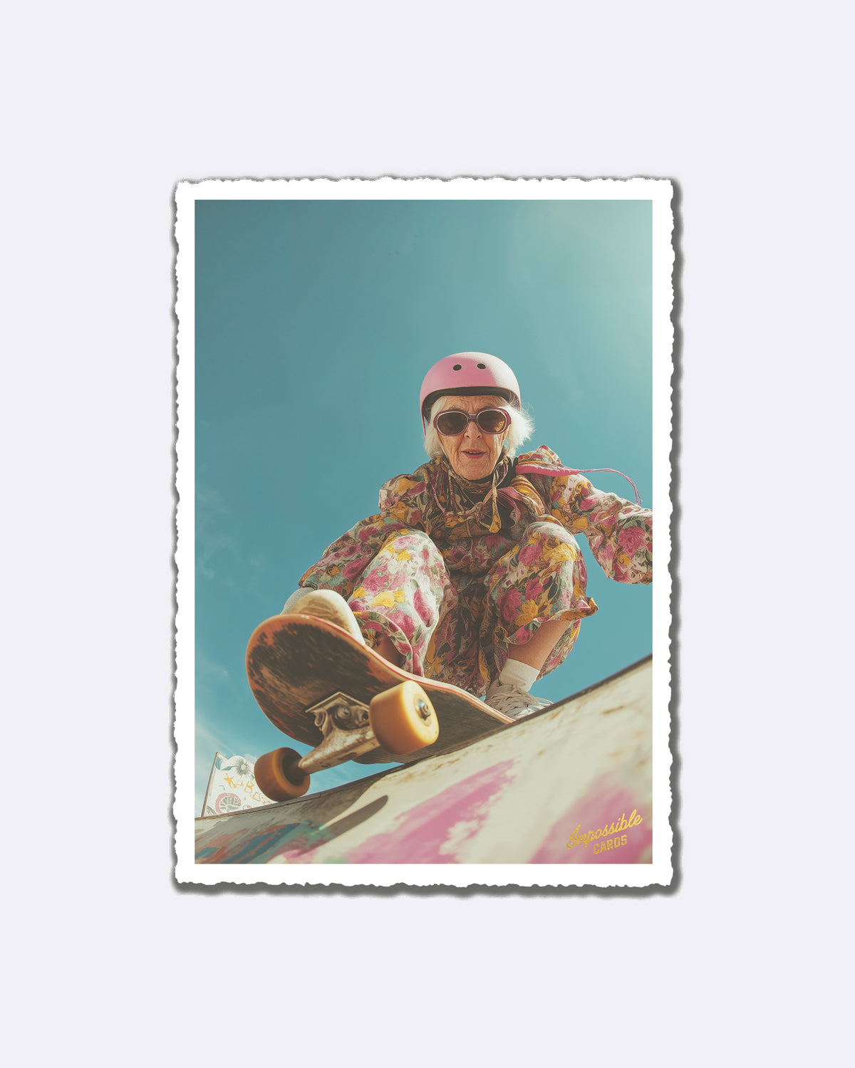 Postkarte mit skaterfahrender Dame in blumigem Outfit und pinkem Helm vor blauem Himmel mit Schriftzug "Impossible Cards"